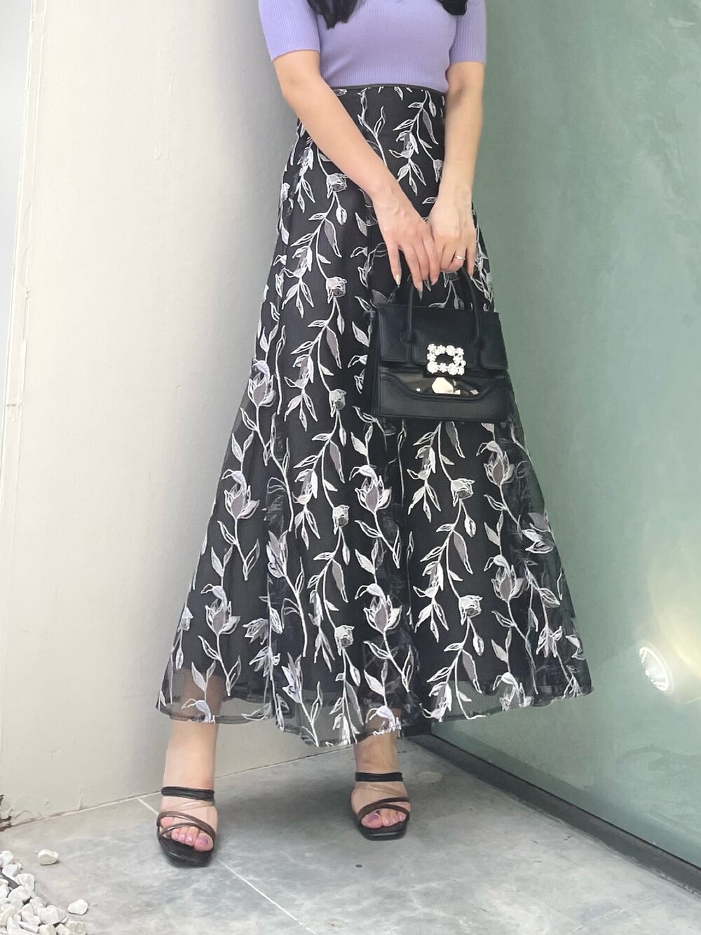 グレー系のスカート、パープル系のニット/セーター、ブラック系のサンダルを着用したレディースの夏コーディネートの7枚目の写真