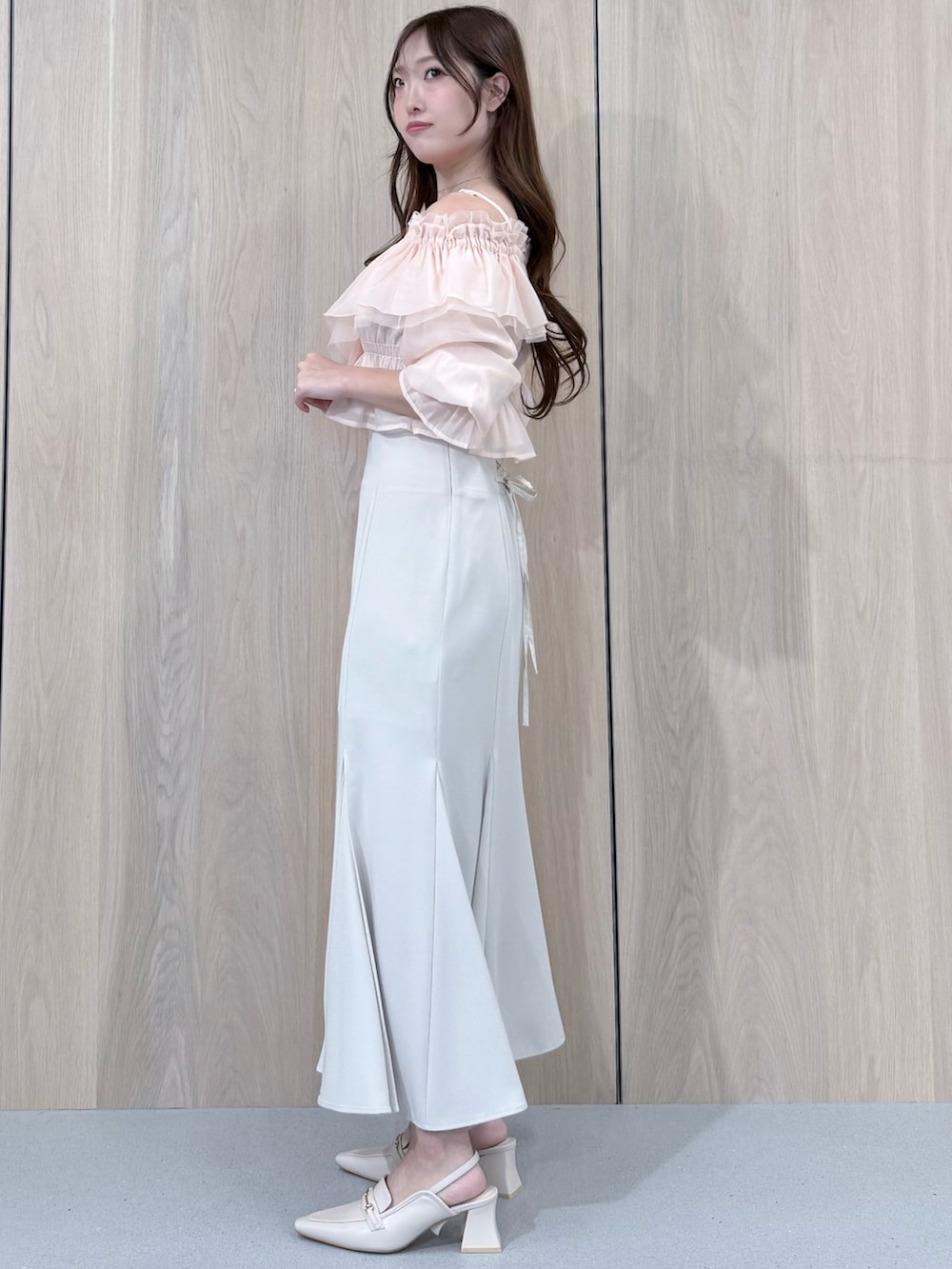 ピンク系のシャツ/ブラウス、ホワイト系のスカート、ホワイト系のパンプスを着用したレディースの春コーディネートの3枚目の写真