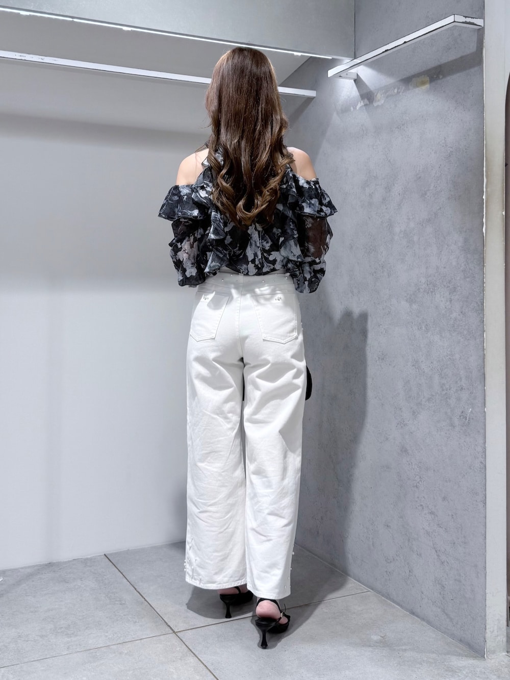 ブラック系のワンピース、ホワイト系のデニムパンツ、ブラック系のサンダルを着用したレディースの夏コーディネートの3枚目の写真