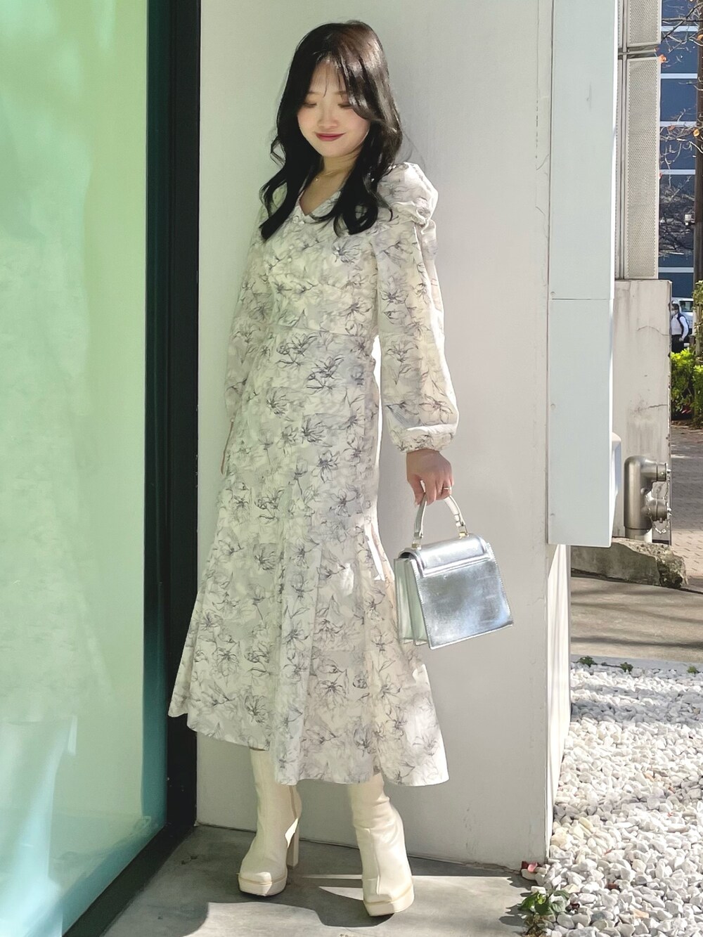 シルバー系のハンドバッグ、ホワイト系のブーツ、ホワイト系のチェスターコートを着用したレディースの冬コーディネートの8枚目の写真