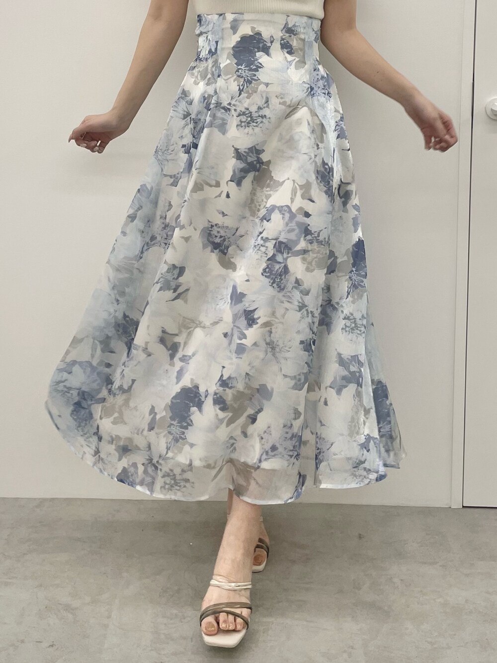 ホワイト系のニット/セーター、ブルー系のスカート、ホワイト系のサンダルを着用したレディースの夏コーディネートの7枚目の写真