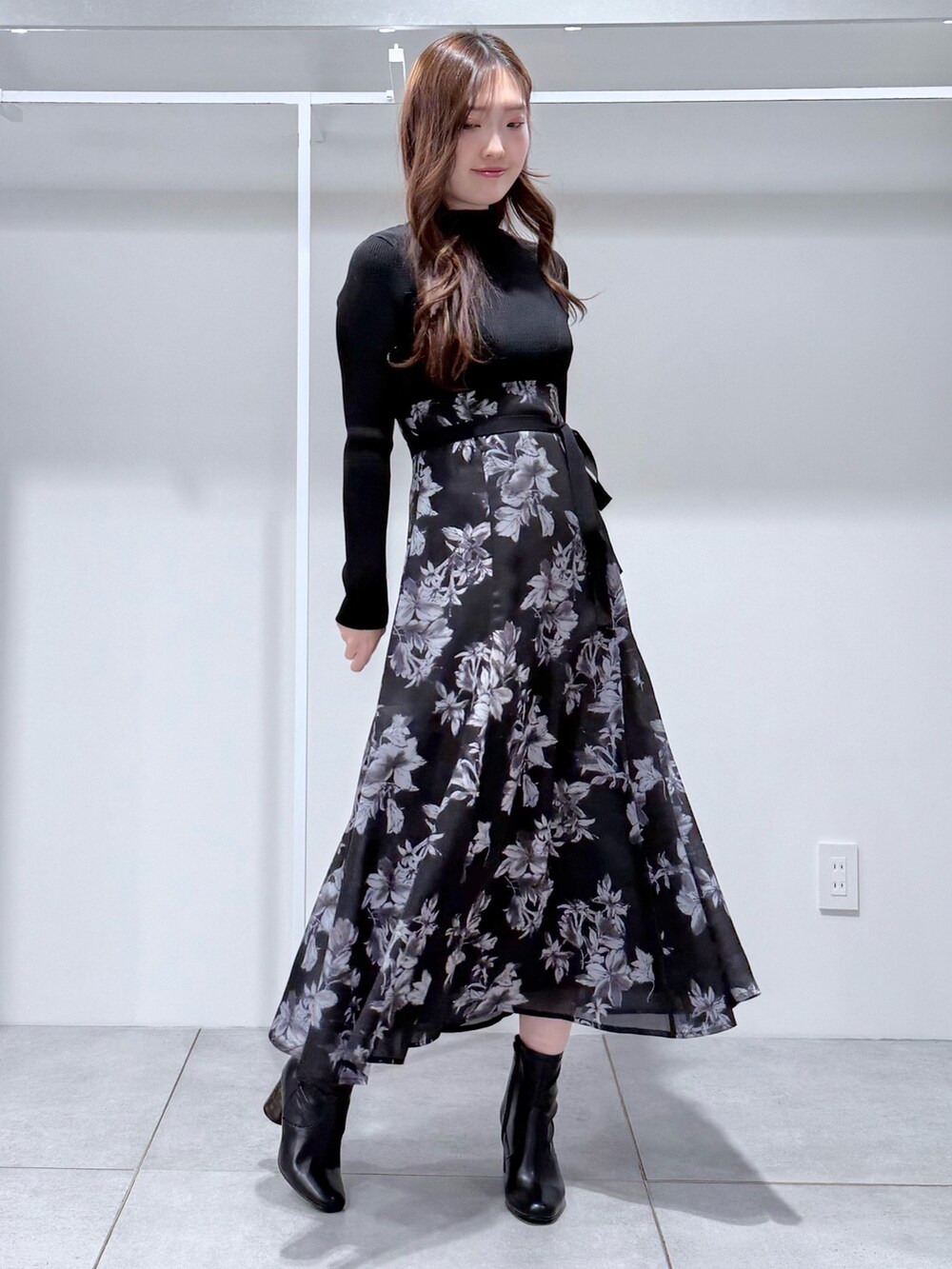 ブラック系のワンピース、ブラック系のブーツを着用したレディースの冬コーディネートの3枚目の写真