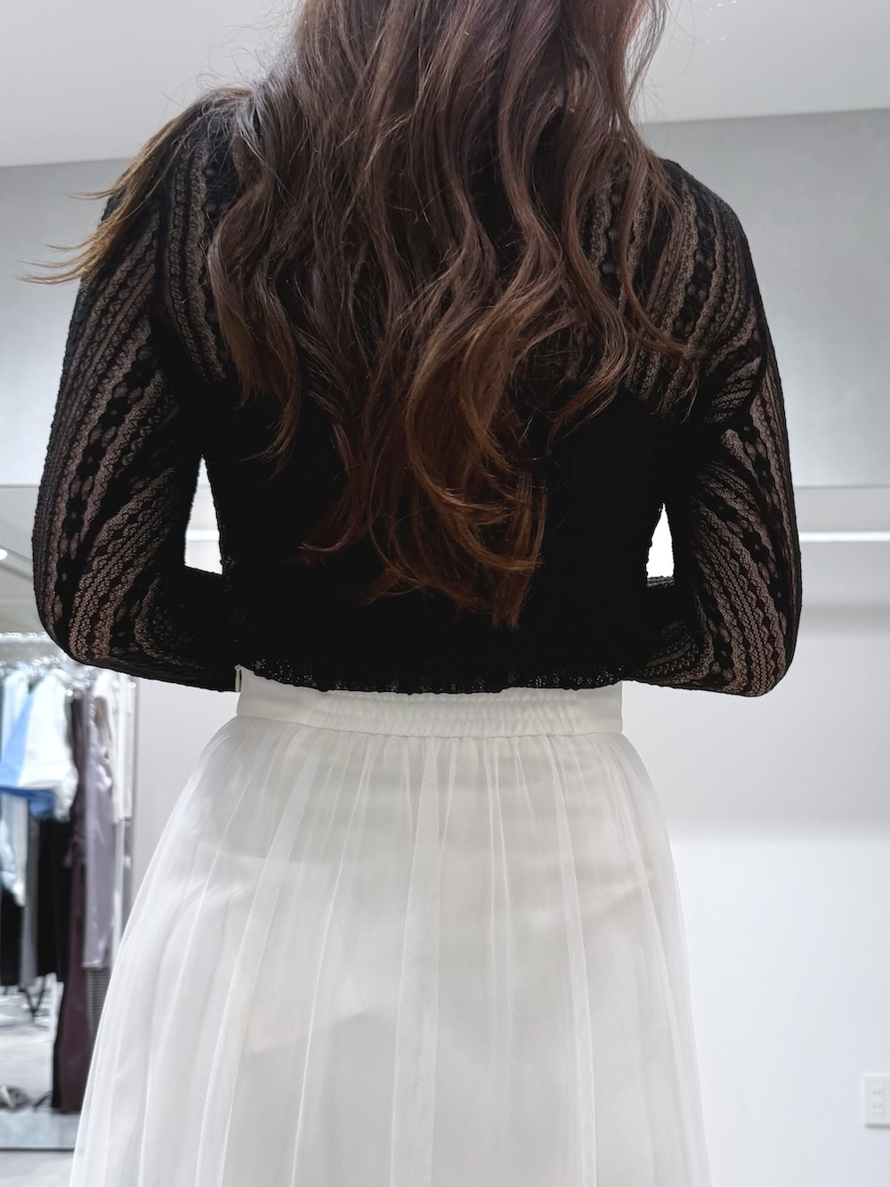 ブラック系のブーツ、ホワイト系のスカート、ブラック系のTシャツ/カットソーを着用したレディースの秋コーディネートの7枚目の写真