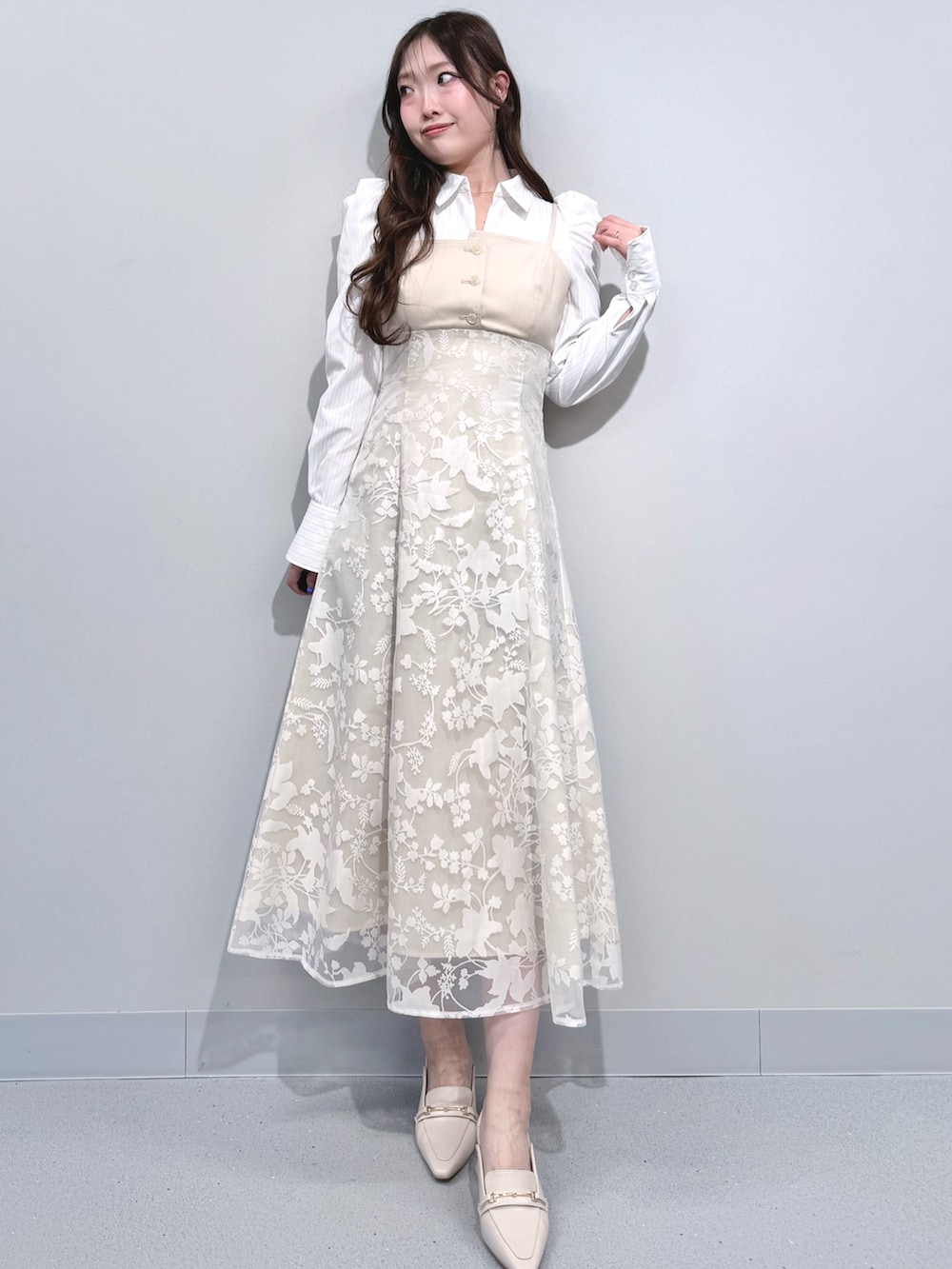 ベージュ系のワンピース、ホワイト系のパンプスを着用したレディースの冬コーディネートの2枚目の写真