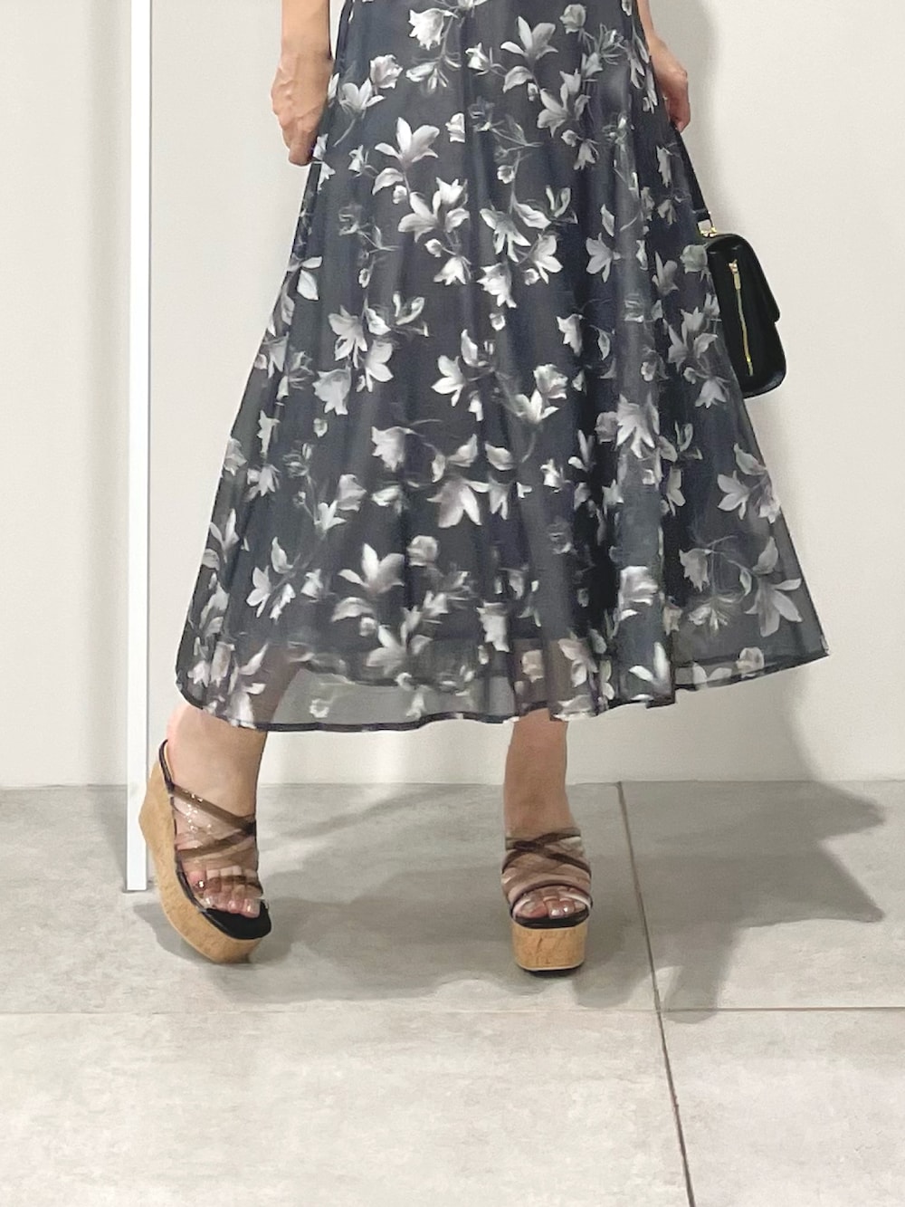 ブラック系のショルダーバッグ、ブラック系のサンダル、グレー系のワンピースを着用したレディースの夏コーディネートの7枚目の写真