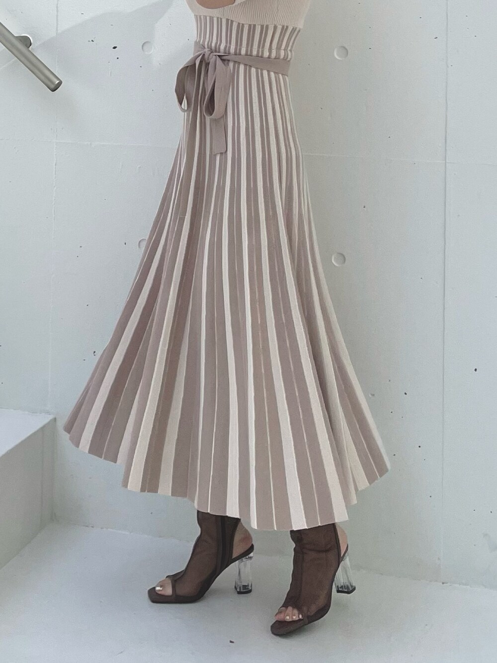 ベージュ系のワンピース、ブラウン系のブーツを着用したレディースの春コーディネートの6枚目の写真