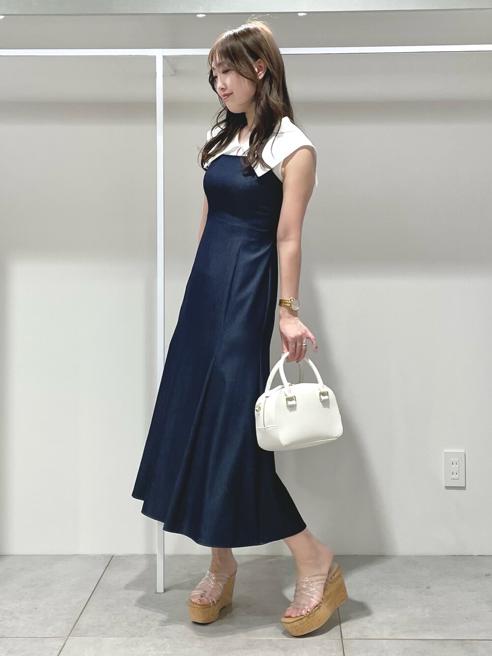 ホワイト系のボストンバッグ、ブルー系のワンピース、その他のサンダルを着用したレディースの春コーディネートの5枚目の写真