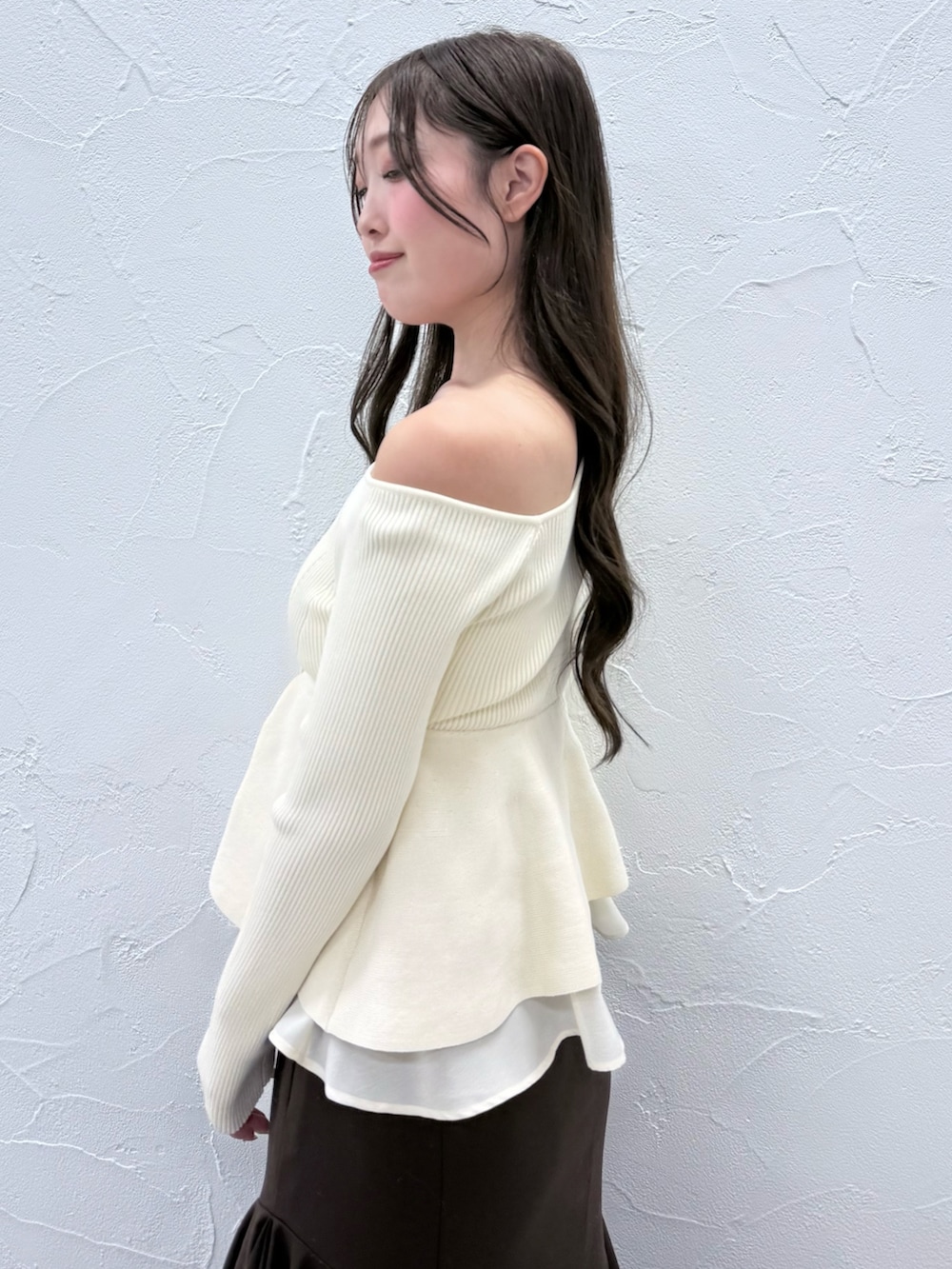 ホワイト系のニット/セーター、ブラウン系のスカート、ブラウン系のブーツを着用したレディースの秋コーディネートの5枚目の写真