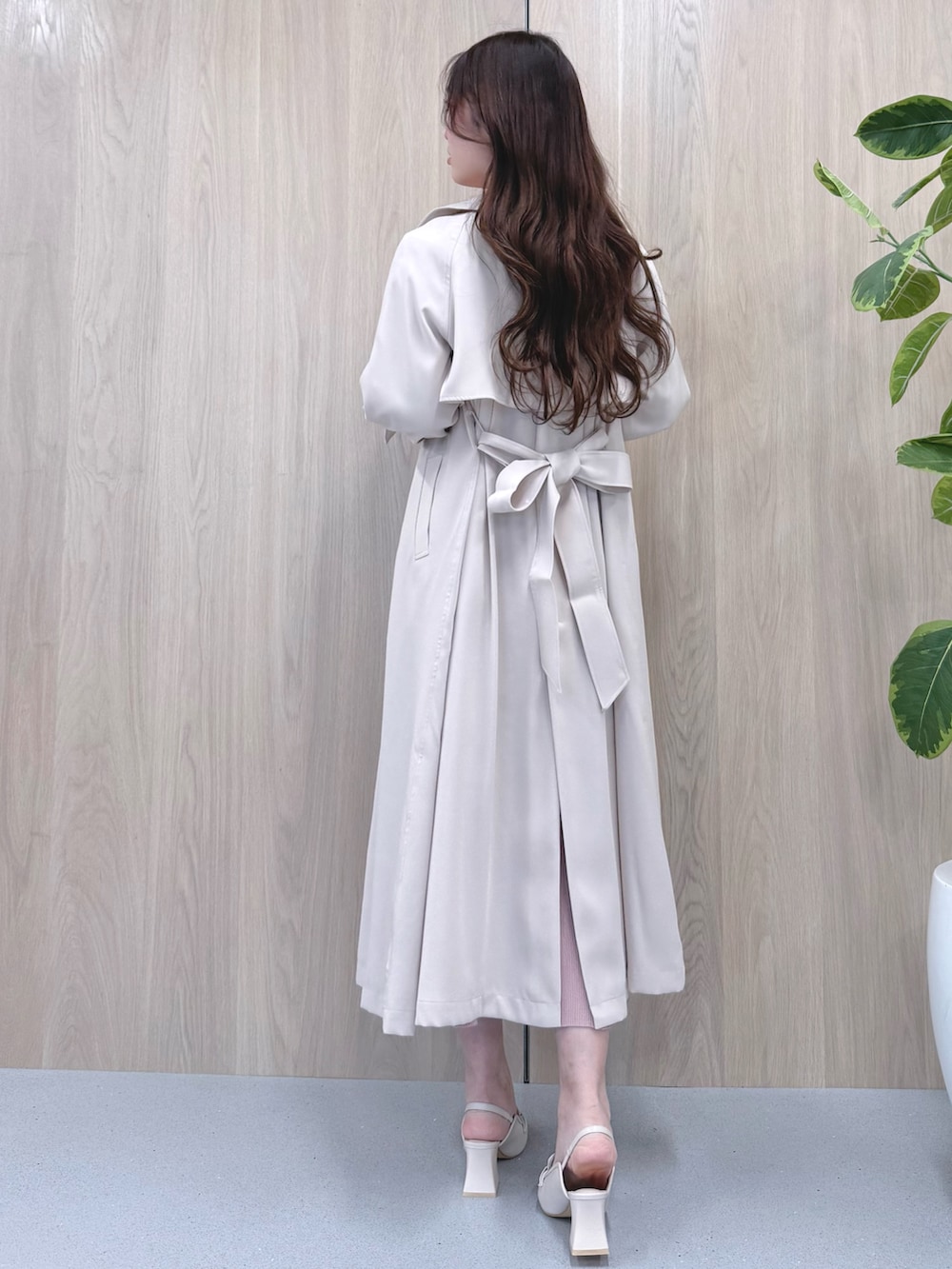 ホワイト系のトレンチコート、ピンク系のワンピース、ホワイト系のパンプスを着用したレディースの冬コーディネートの3枚目の写真