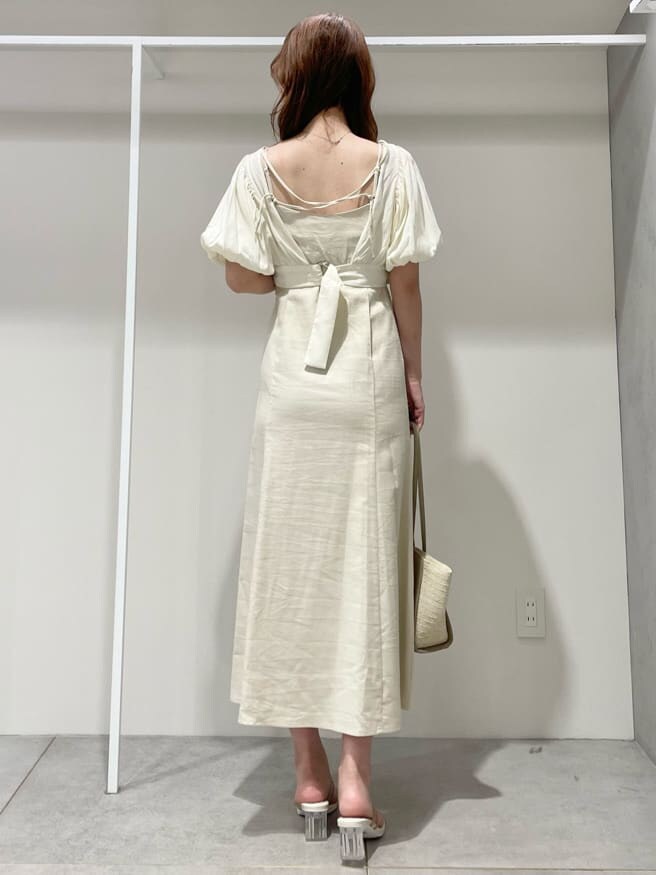 ベージュ系のサンダル、ベージュ系のトートバッグ、ホワイト系のワンピースを着用したレディースの春コーディネートの3枚目の写真