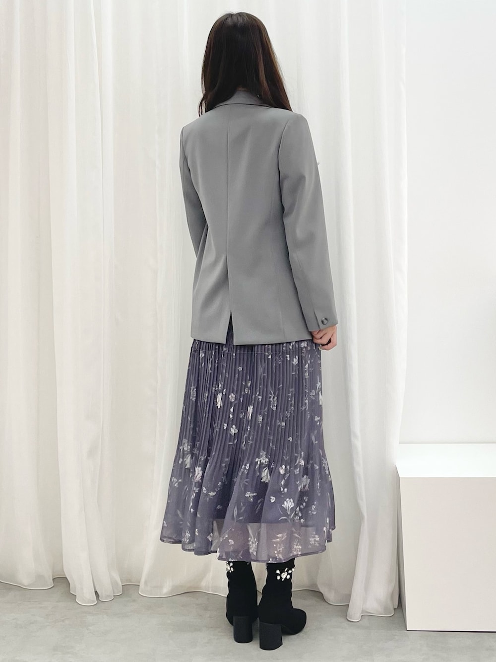 グレー系のワンピース、ブラック系のブーツ、グレー系のテーラードジャケットを着用したレディースの秋コーディネートの3枚目の写真