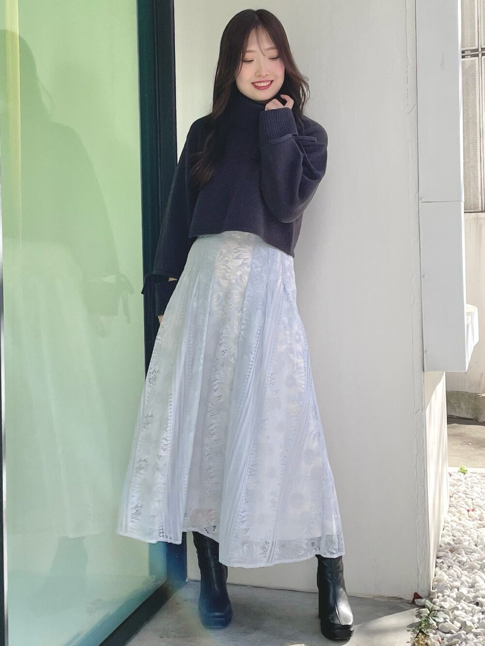 ブルー系のスカート、グレー系のニット/セーター、ブラック系のブーツを着用したレディースの冬コーディネートの3枚目の写真