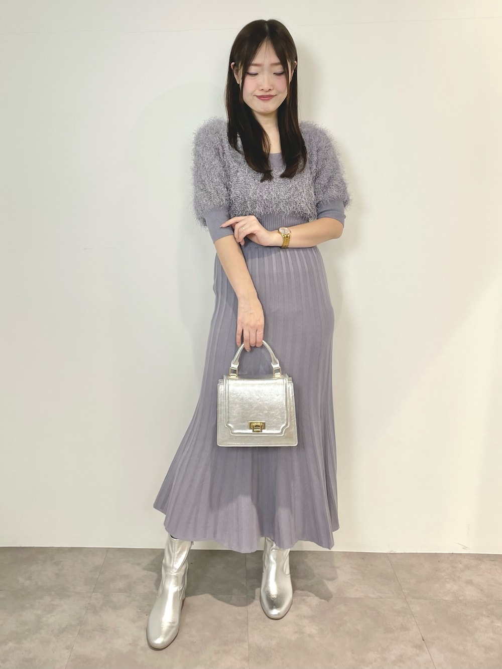 ブルー系のワンピース、シルバー系のハンドバッグ、シルバー系のブーツを着用したレディースの冬コーディネートの2枚目の写真