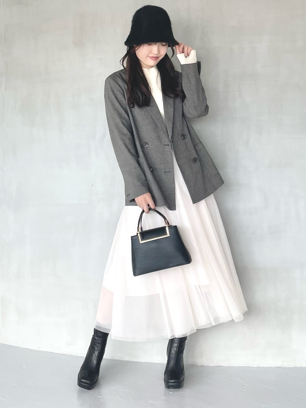 ブラック系のブーツ、ブラウン系のテーラードジャケット、ブラック系のハンドバッグを着用したレディースの秋コーディネートの4枚目の写真