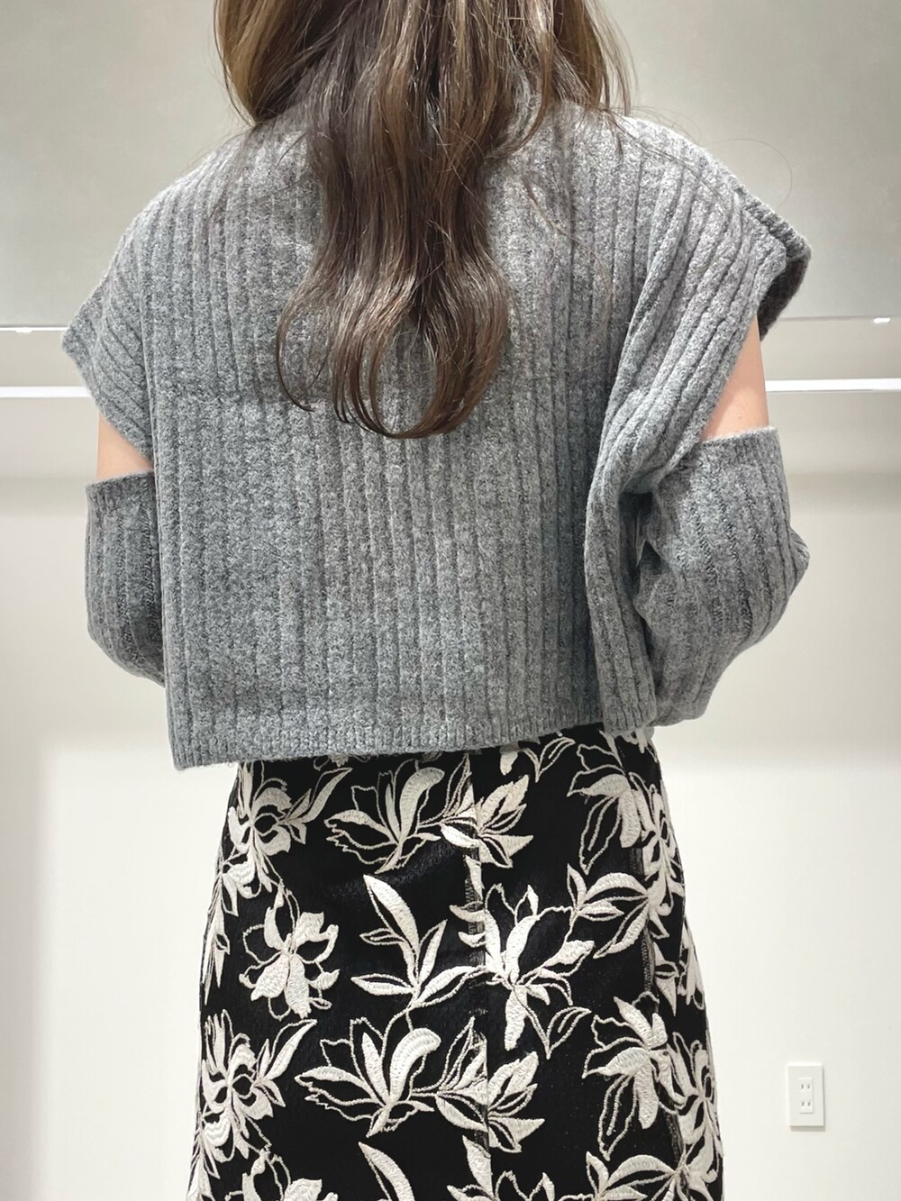 ブラック系のスカート、ブラック系のブーツ、グレー系のニット/セーターを着用したレディースの冬コーディネートの5枚目の写真