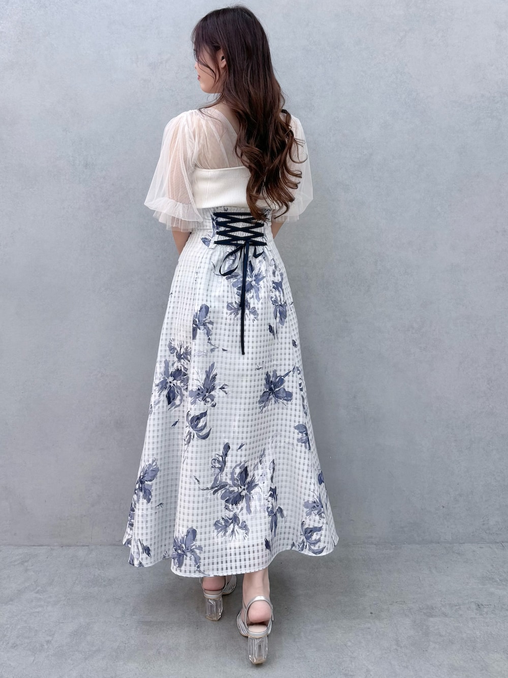 ホワイト系のニット/セーター、シルバー系のサンダル、ブルー系のスカートを着用したレディースの春コーディネートの4枚目の写真