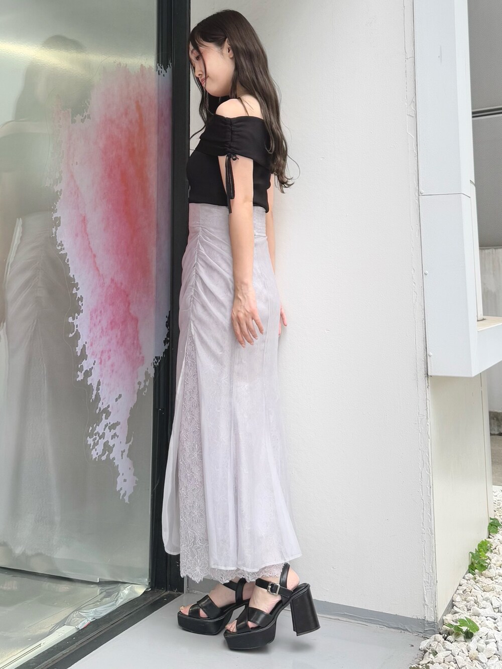 パープル系のスカート、ブラック系のニット/セーター、ブラック系のサンダルを着用したレディースの夏コーディネートの3枚目の写真