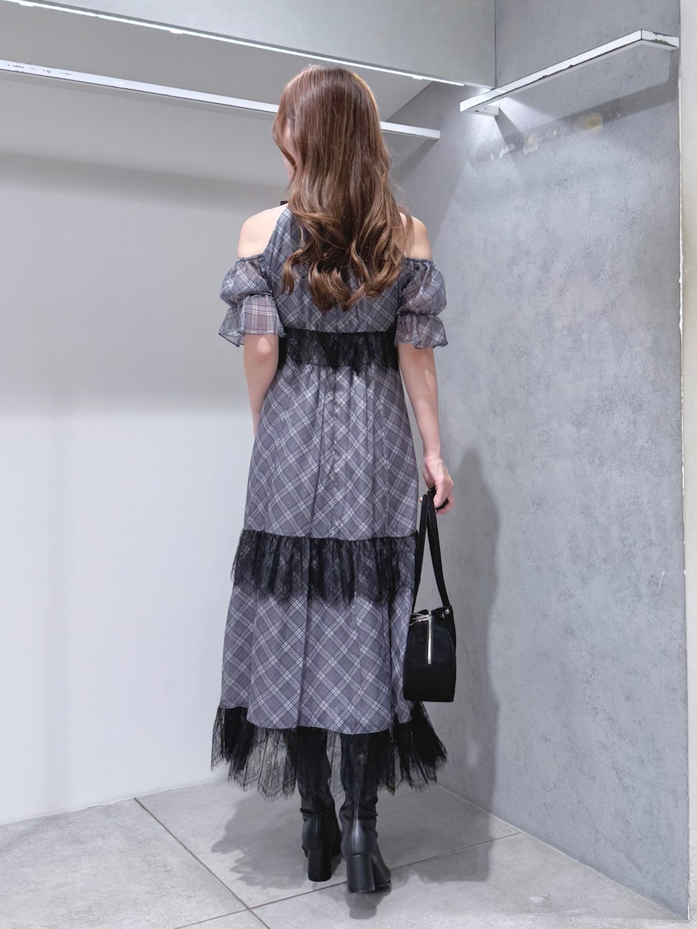 ブラック系のワンピース、ブラック系のハンドバッグ、ブラック系のブーツを着用したレディースの夏コーディネートの4枚目の写真