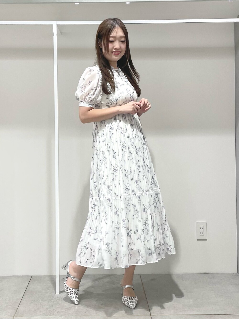 ホワイト系のトレンチコート、ホワイト系のワンピース、シルバー系のパンプスを着用したレディースの春コーディネートの5枚目の写真