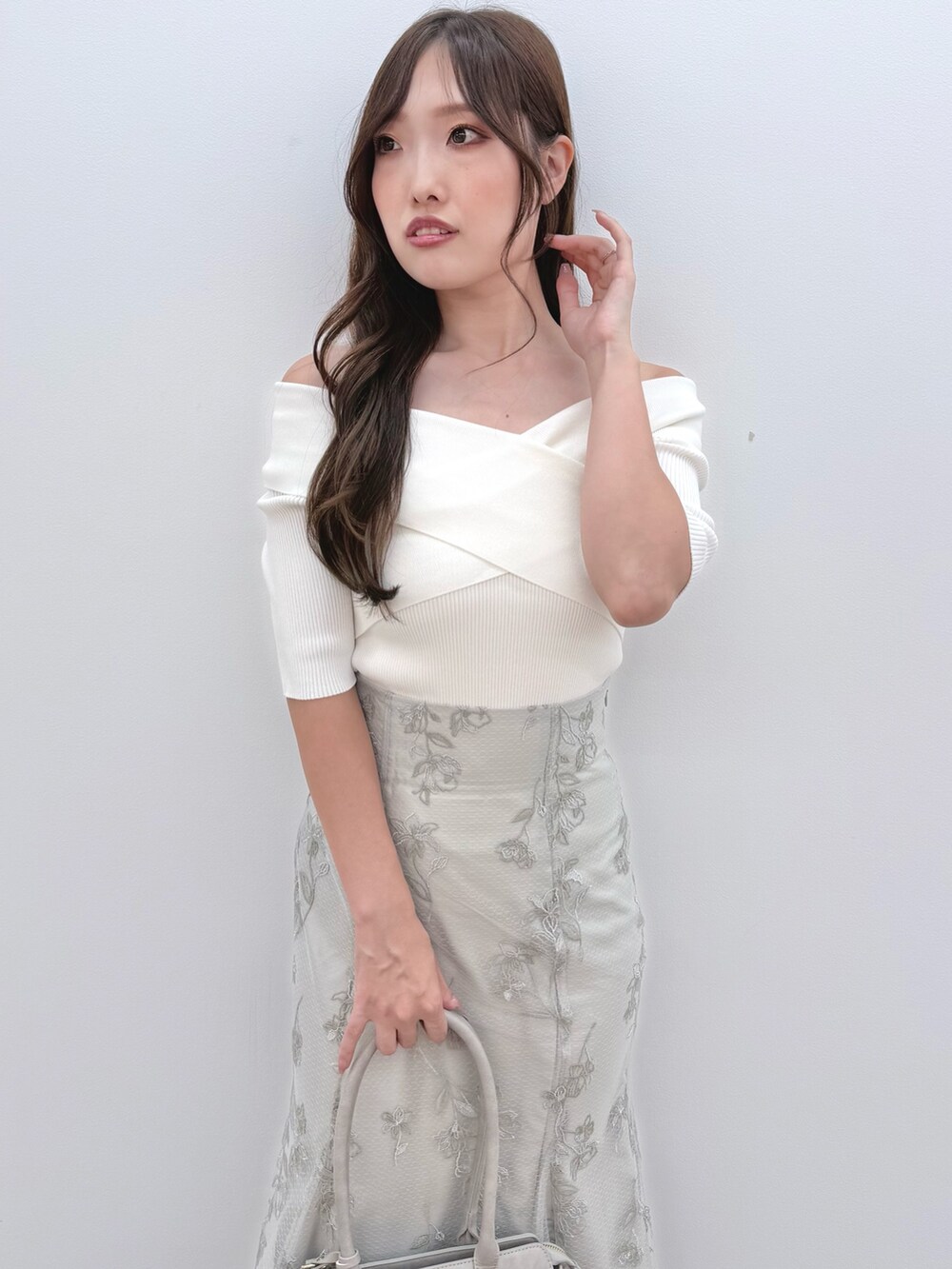 ホワイト系のニット/セーター、ホワイト系のブーツ、グリーン系のスカートを着用したレディースの秋コーディネートの5枚目の写真