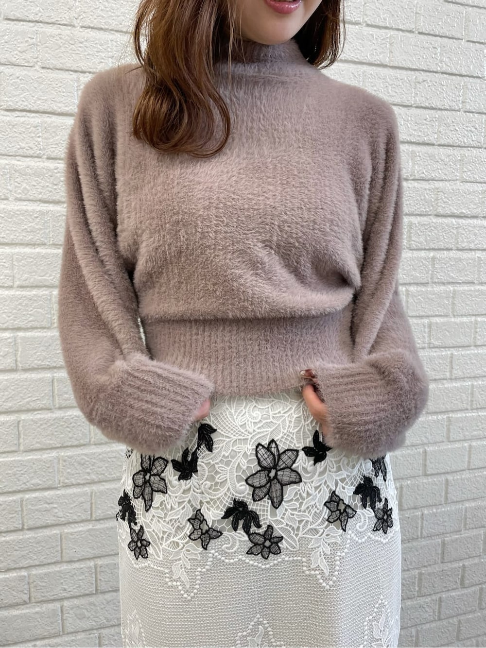 ブラウン系のニット/セーター、ホワイト系のスカート、ホワイト系のその他シューズを着用したレディースの秋コーディネートの3枚目の写真