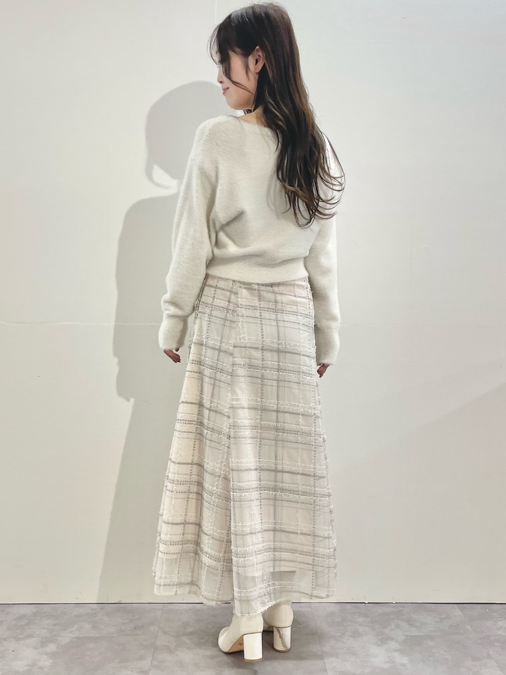 ホワイト系のその他アウター、ホワイト系のスカート、ホワイト系のブーツを着用したレディースの冬コーディネートの5枚目の写真