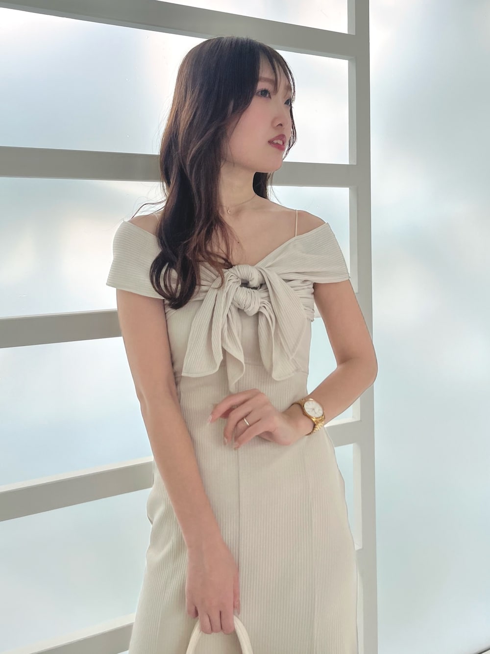 ホワイト系のワンピース、ブラウン系のサンダル、ホワイト系のハンドバッグを着用したレディースの春コーディネートの5枚目の写真