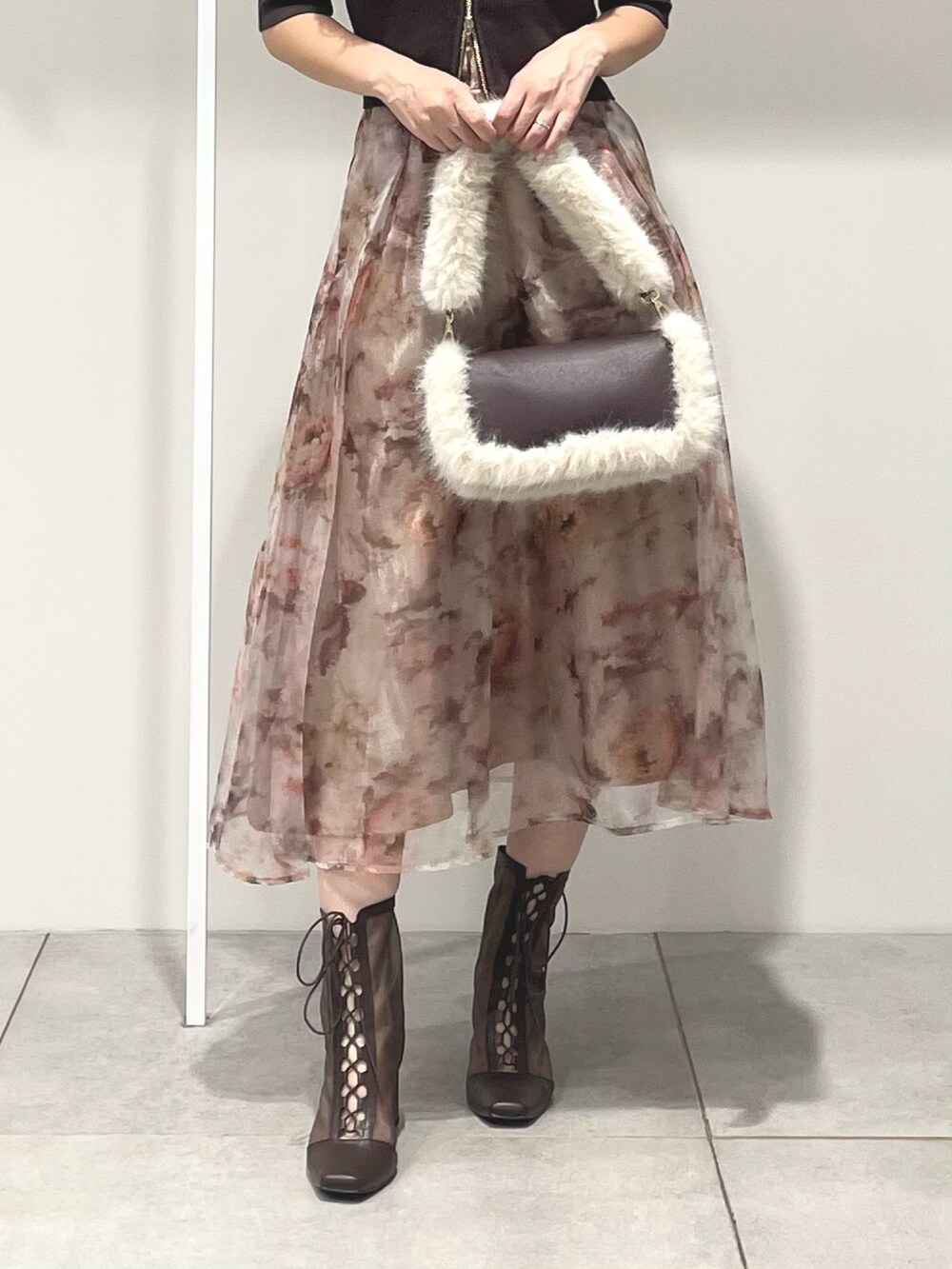 ブラウン系のニット/セーター、ピンク系のスカート、ブラウン系のブーツを着用したレディースの秋コーディネートの7枚目の写真