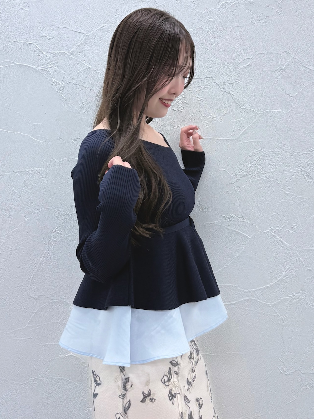 ブルー系のニット/セーター、ホワイト系のスカート、ブラック系のブーツを着用したレディースの秋コーディネートの5枚目の写真