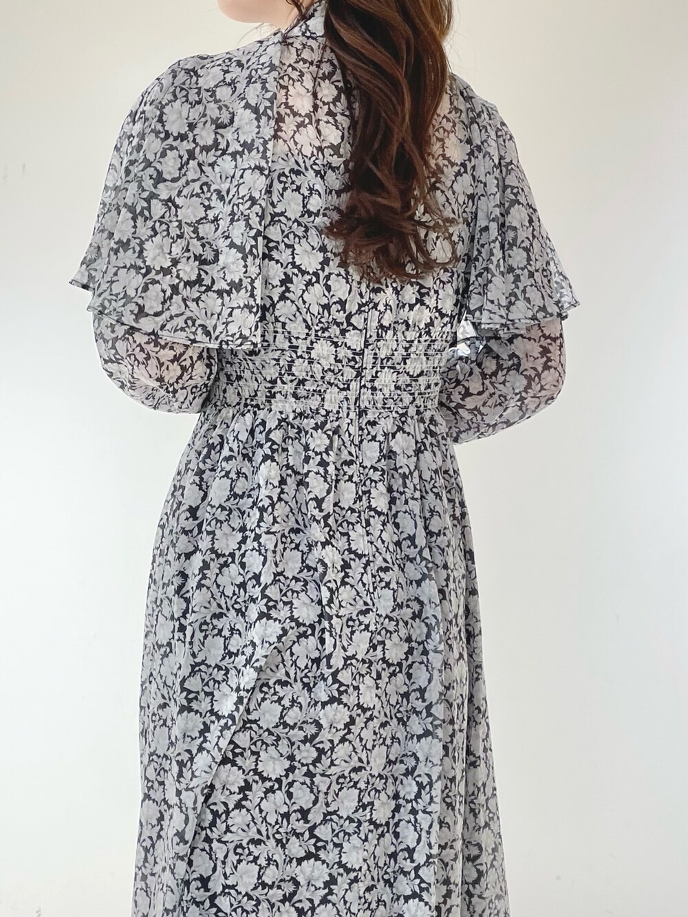 ブラック系のワンピース、ブラック系のサンダルを着用したレディースの冬コーディネートの6枚目の写真