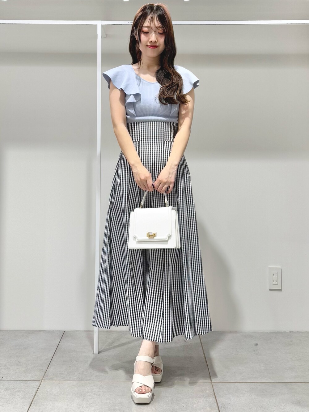 ブルー系のニット/セーター、その他のスカート、ホワイト系のサンダルを着用したレディースの春コーディネートの2枚目の写真