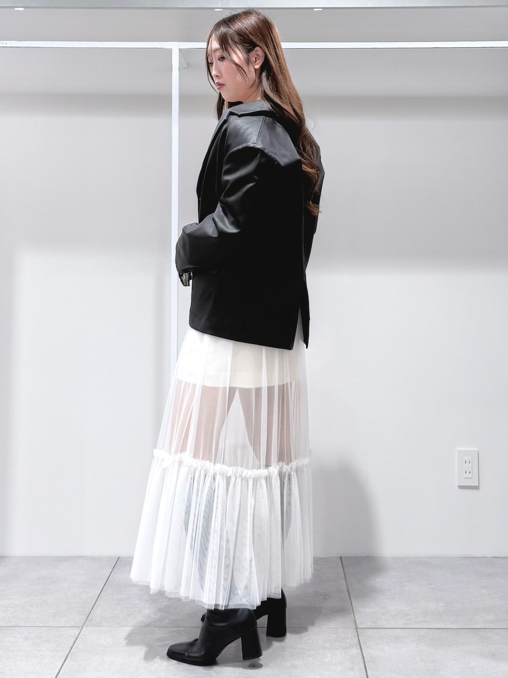 ブラック系のテーラードジャケット、ブラック系のTシャツ/カットソー、ブラック系のブーツを着用したレディースの秋コーディネートの3枚目の写真