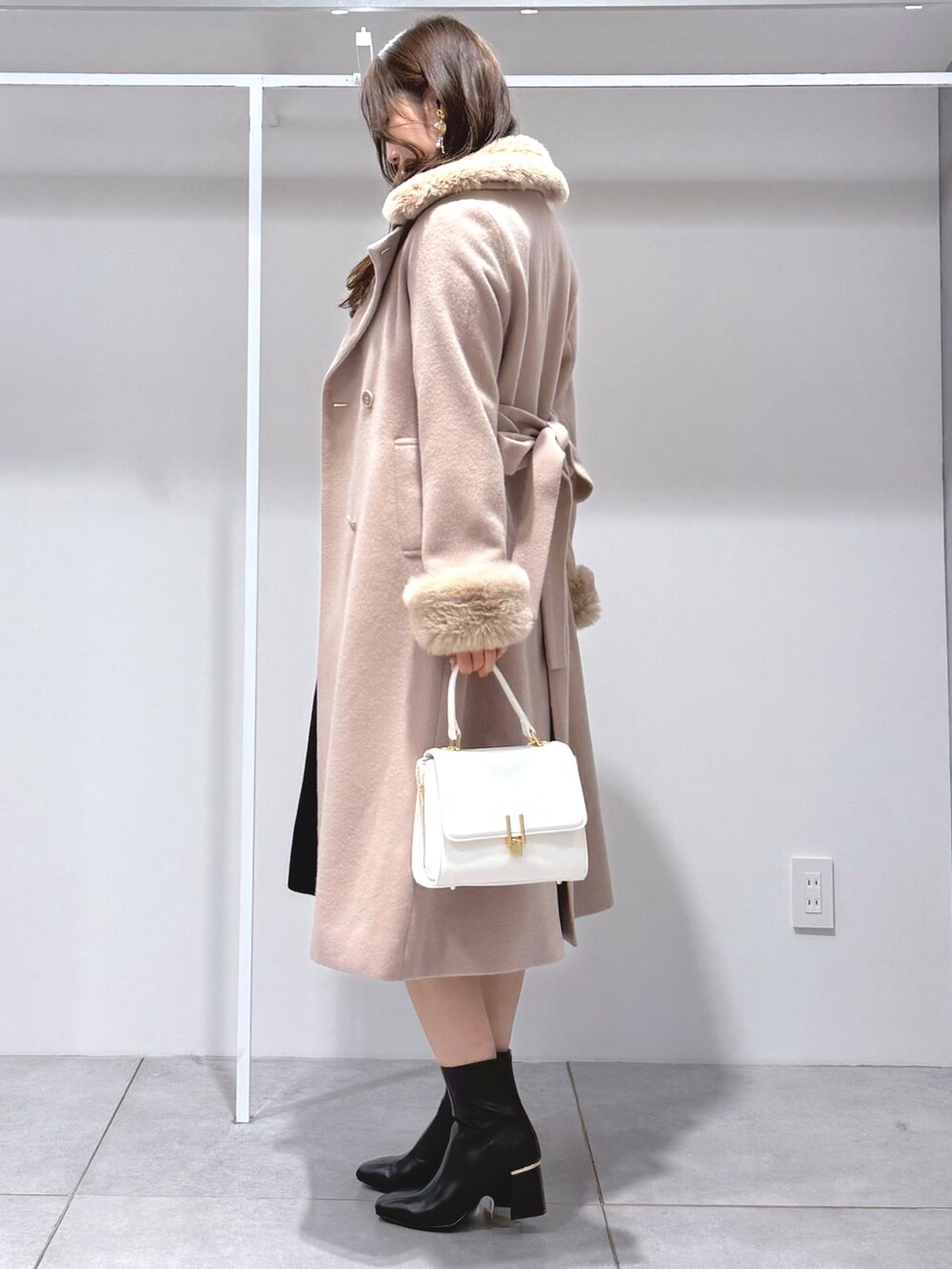 ベージュ系のその他アウター、ホワイト系のハンドバッグ、ブラック系のワンピースを着用したレディースの冬コーディネートの3枚目の写真