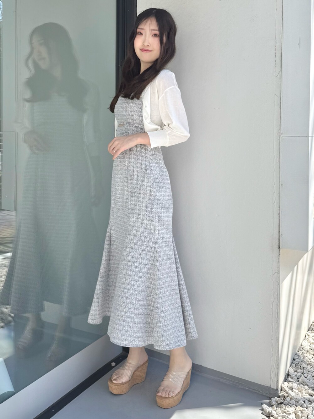 グレー系のワンピース、ホワイト系のカーディガン/ボレロ、その他のサンダルを着用したレディースの春コーディネートの2枚目の写真
