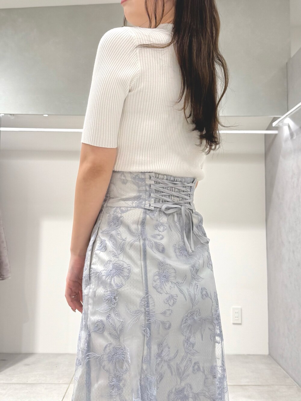 ホワイト系のニット/セーター、ブルー系のスカート、ホワイト系のパンプスを着用したレディースの春コーディネートの6枚目の写真