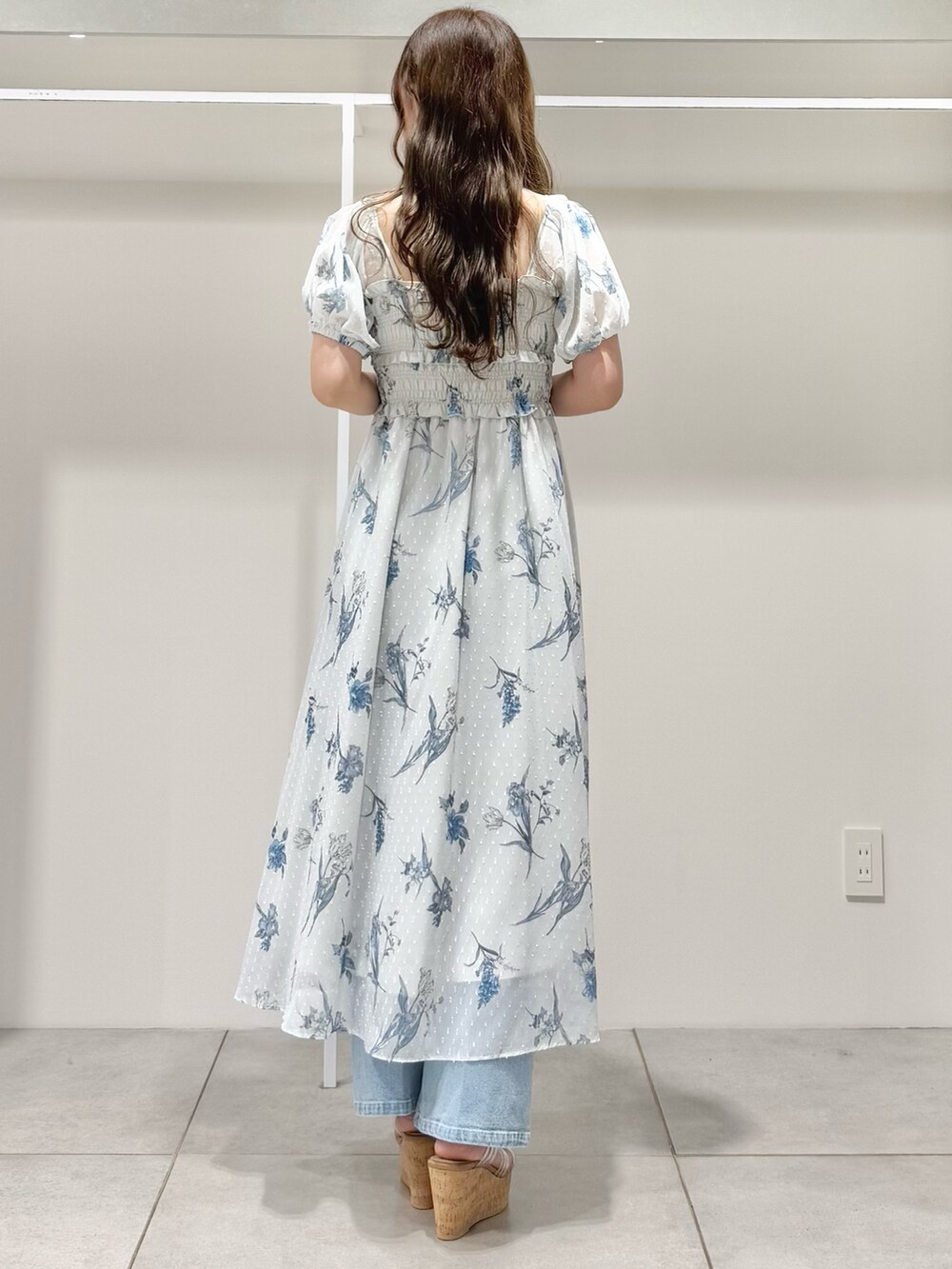 グレー系のワンピース、ブルー系のデニムパンツ、その他のサンダルを着用したレディースの春コーディネートの5枚目の写真