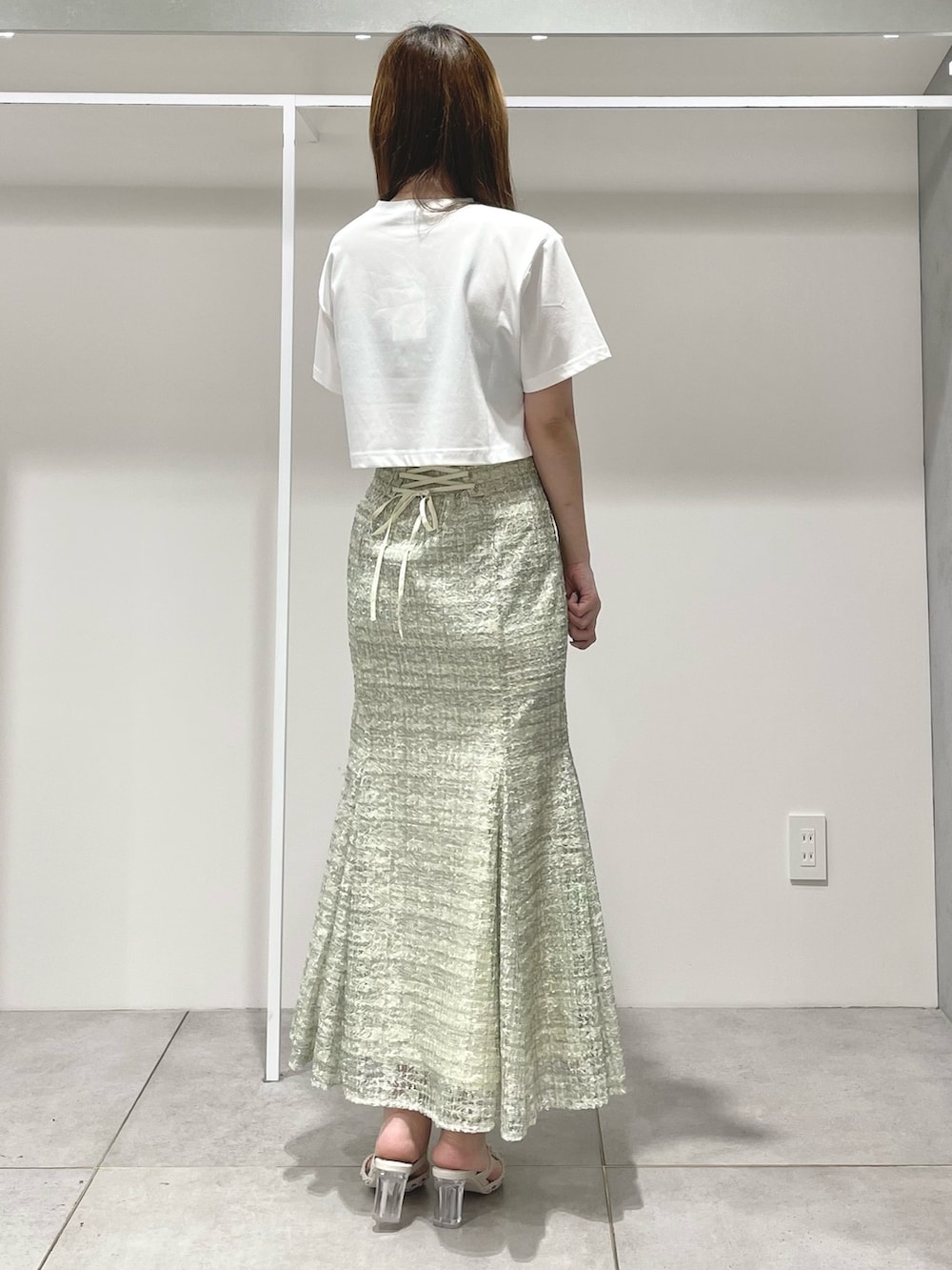 ホワイト系のTシャツ/カットソー、ホワイト系のショルダーバッグ、グリーン系のスカートを着用したレディースの春コーディネートの3枚目の写真