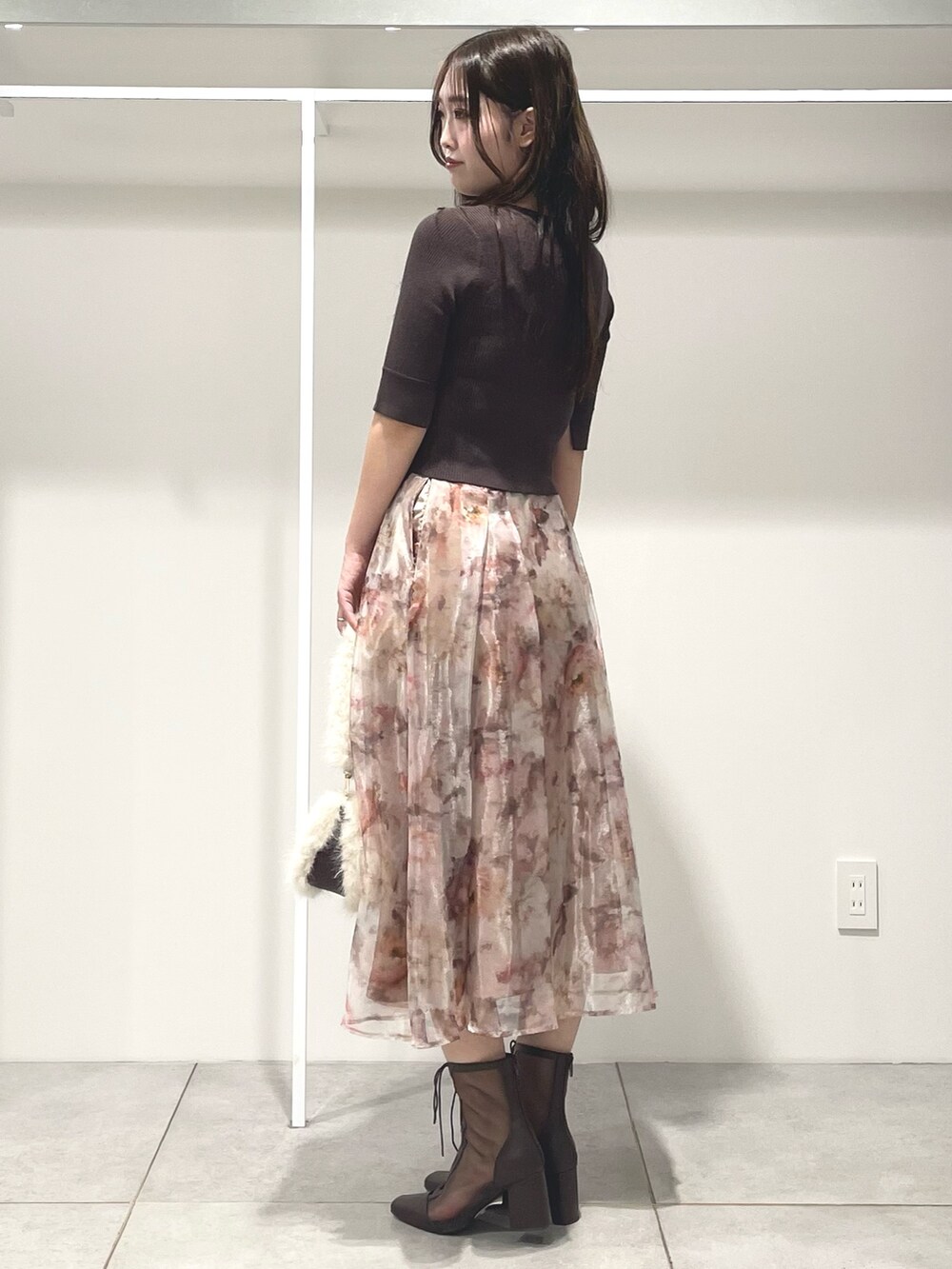 ブラウン系のニット/セーター、ピンク系のスカート、ブラウン系のブーツを着用したレディースの秋コーディネートの3枚目の写真