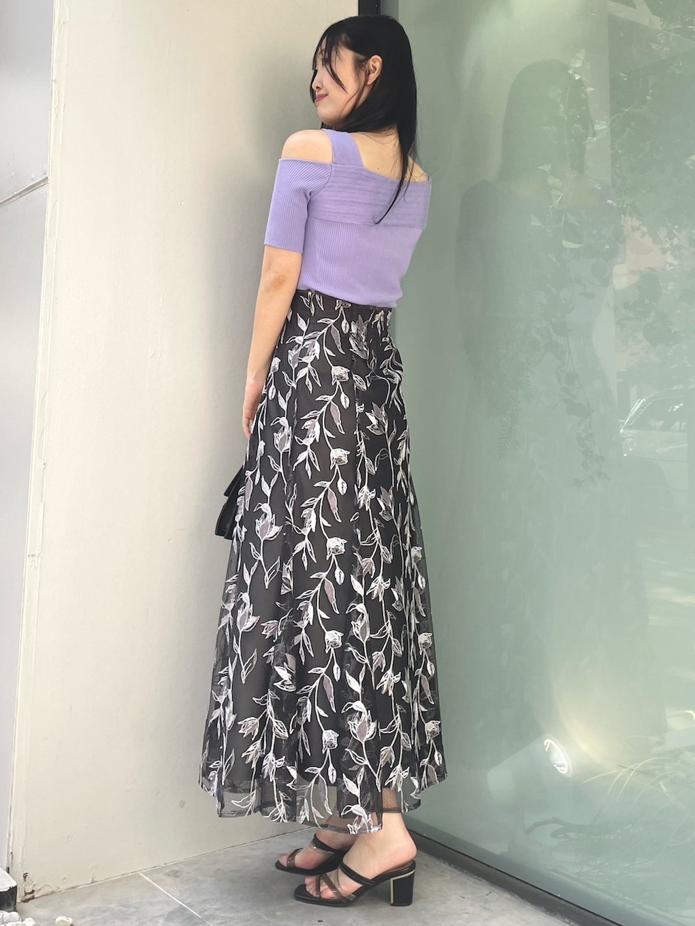 グレー系のスカート、パープル系のニット/セーター、ブラック系のサンダルを着用したレディースの夏コーディネートの2枚目の写真