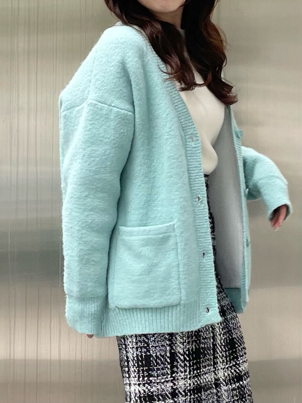 グリーン系のカーディガン/ボレロ、ブラック系のスカート、ブラック系のブーツを着用したレディースの秋コーディネートの4枚目の写真