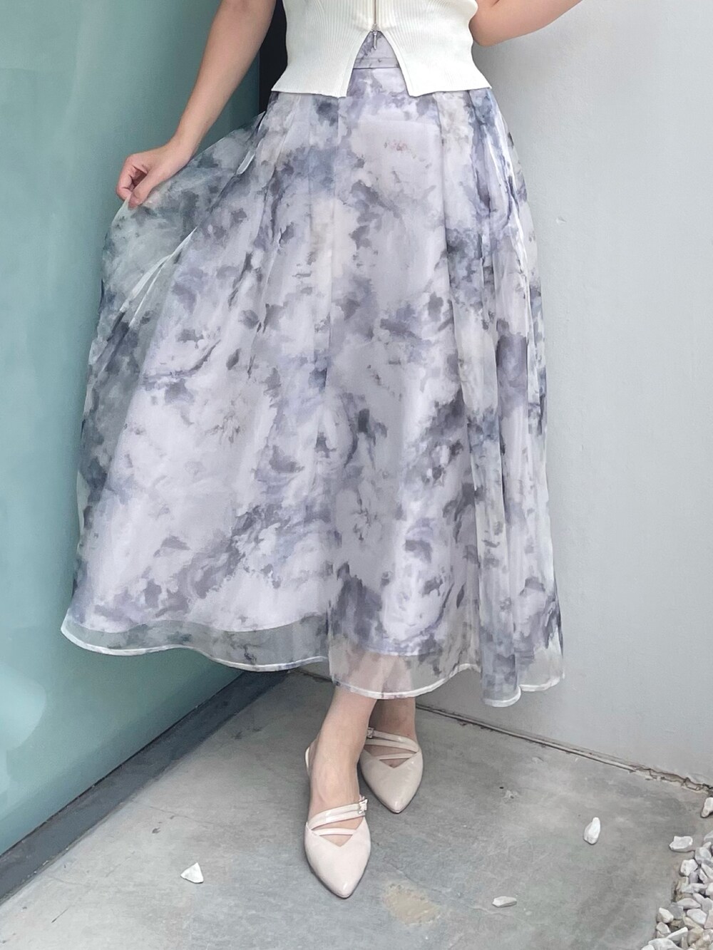 ホワイト系のニット/セーター、グレー系のスカート、ベージュ系のパンプスを着用したレディースの夏コーディネートの7枚目の写真