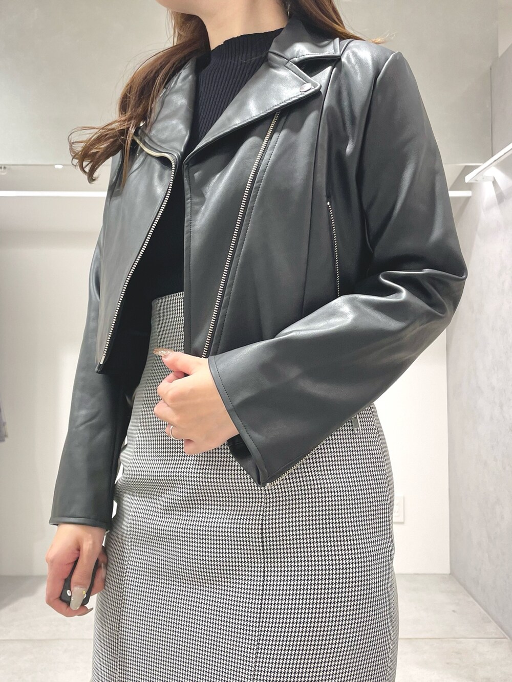 ブラック系のライダースジャケット、ブラック系のニット/セーター、その他のスカートを着用したレディースの秋コーディネートの4枚目の写真