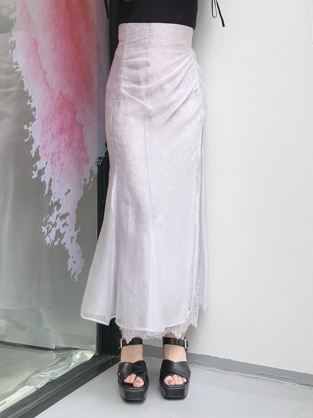 パープル系のスカート、ブラック系のニット/セーター、ブラック系のサンダルを着用したレディースの夏コーディネートの8枚目の写真