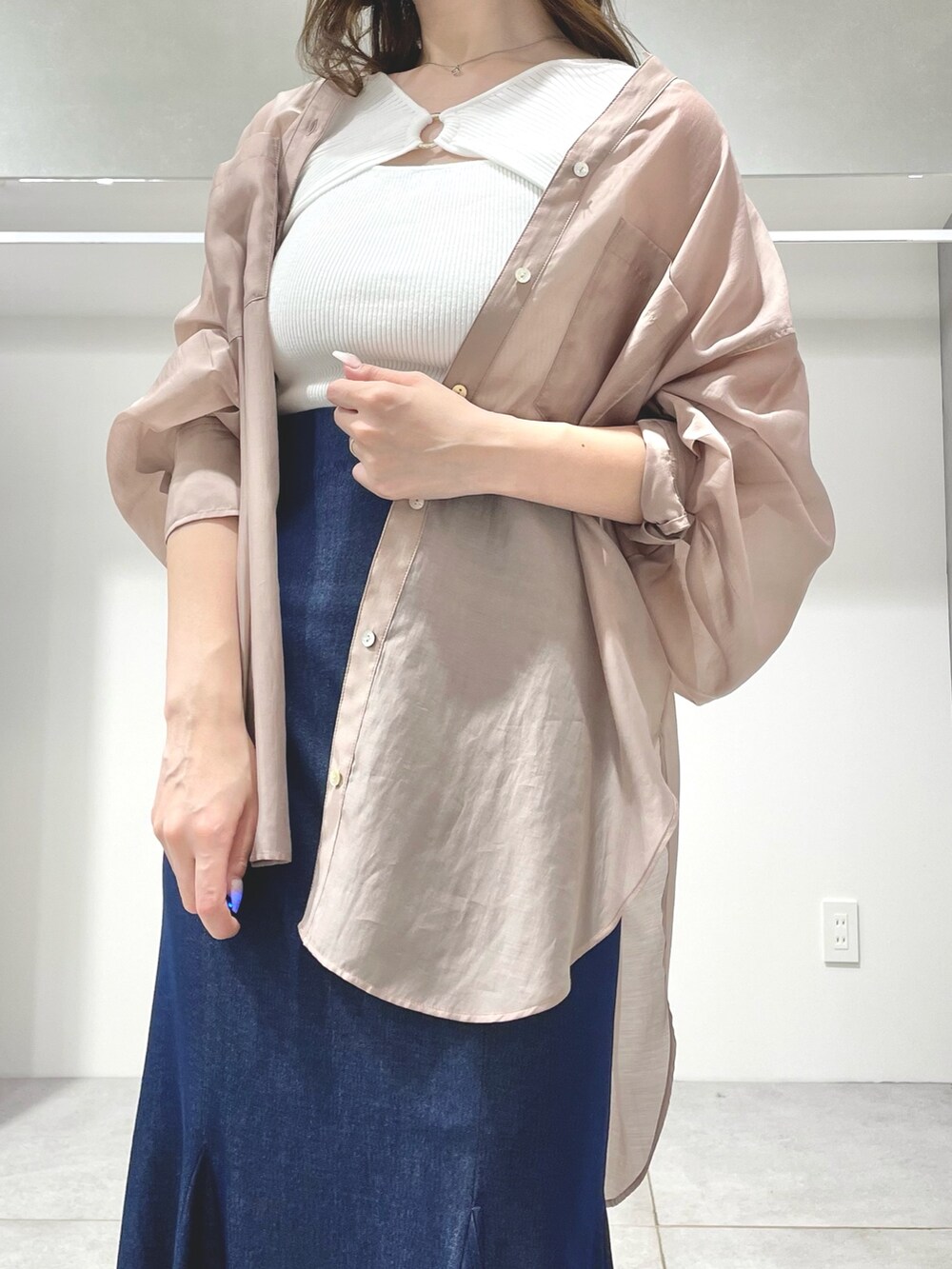 ブルー系のスカート、ブラック系のサンダル、ベージュ系のシャツ/ブラウスを着用したレディースの春コーディネートの4枚目の写真