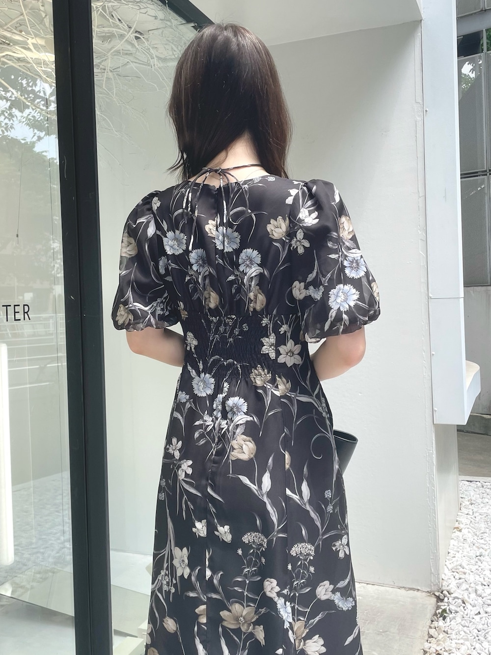 ブラック系のトートバッグ、ブラウン系のブーツ、ブラック系のワンピースを着用したレディースの夏コーディネートの7枚目の写真