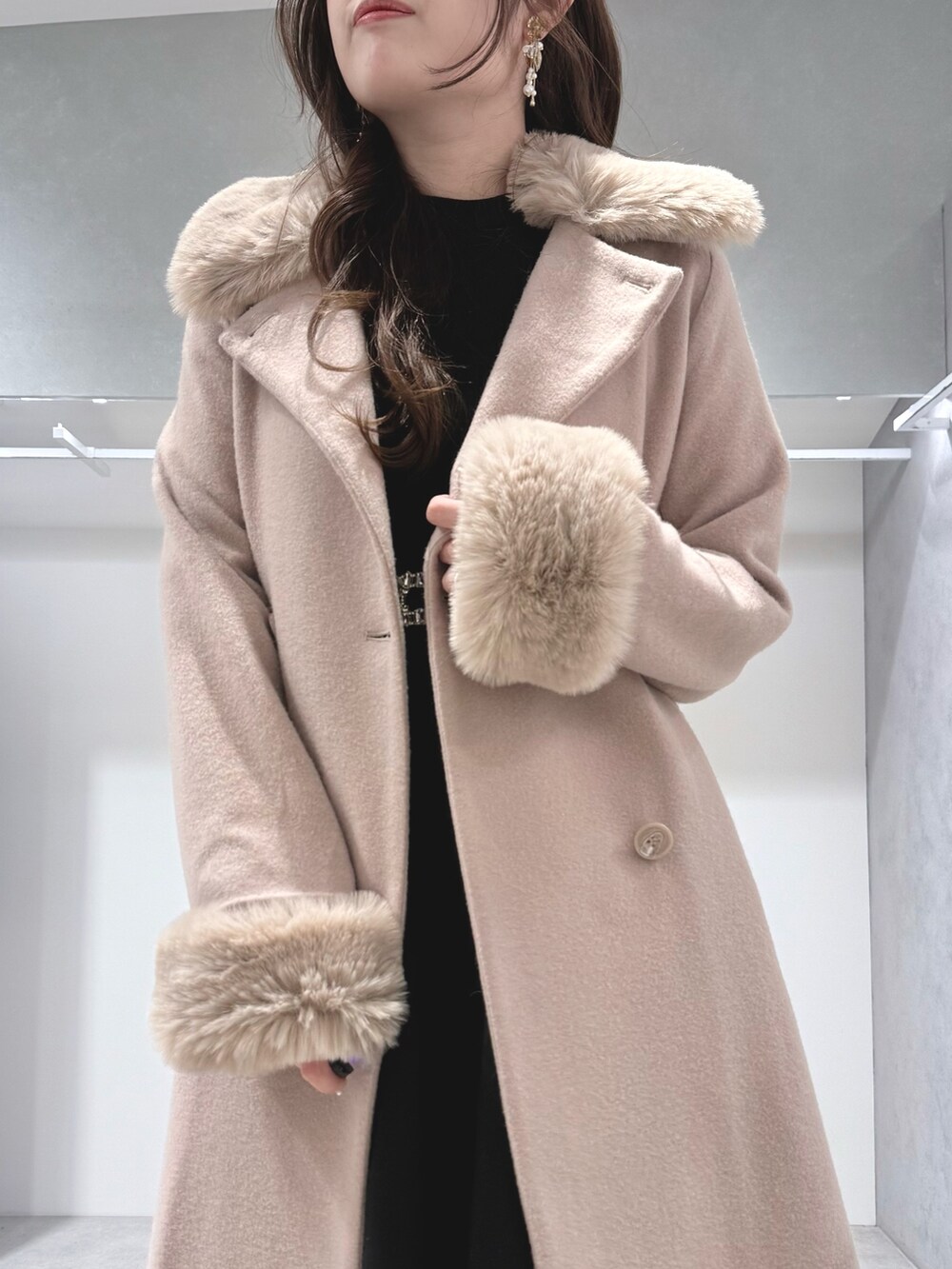 ベージュ系のその他アウター、ホワイト系のハンドバッグ、ブラック系のワンピースを着用したレディースの冬コーディネートの5枚目の写真