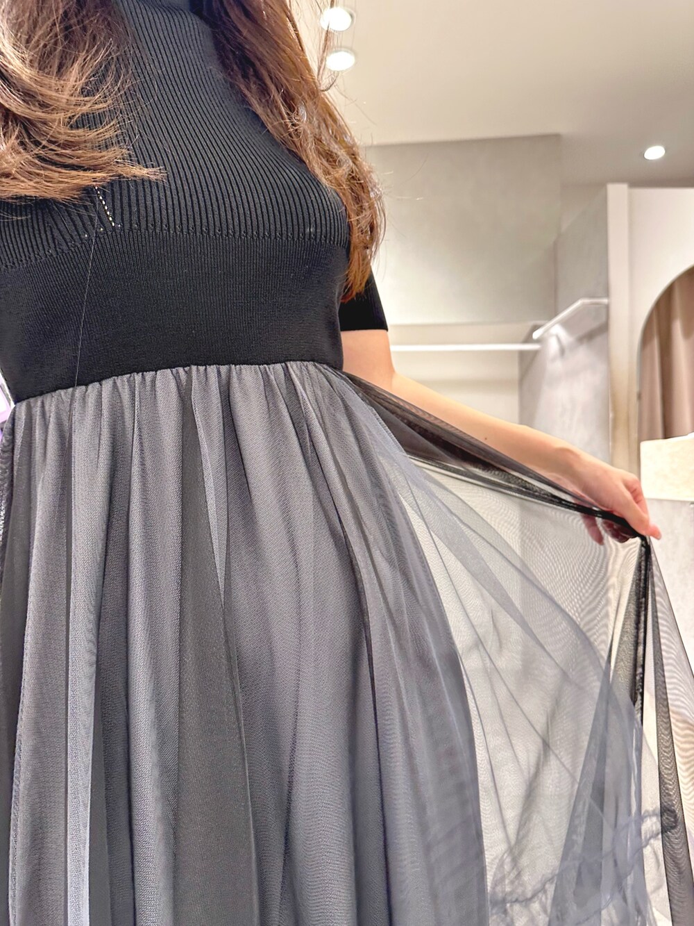 ブラック系のワンピース、ブラック系のショルダーバッグ、ブラック系のパンプスを着用したレディースの夏コーディネートの6枚目の写真