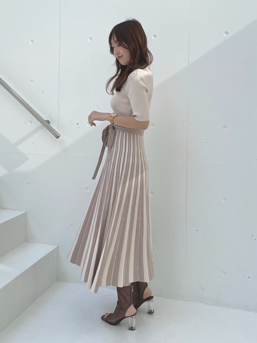 ベージュ系のワンピース、ブラウン系のブーツを着用したレディースの春コーディネートの2枚目の写真