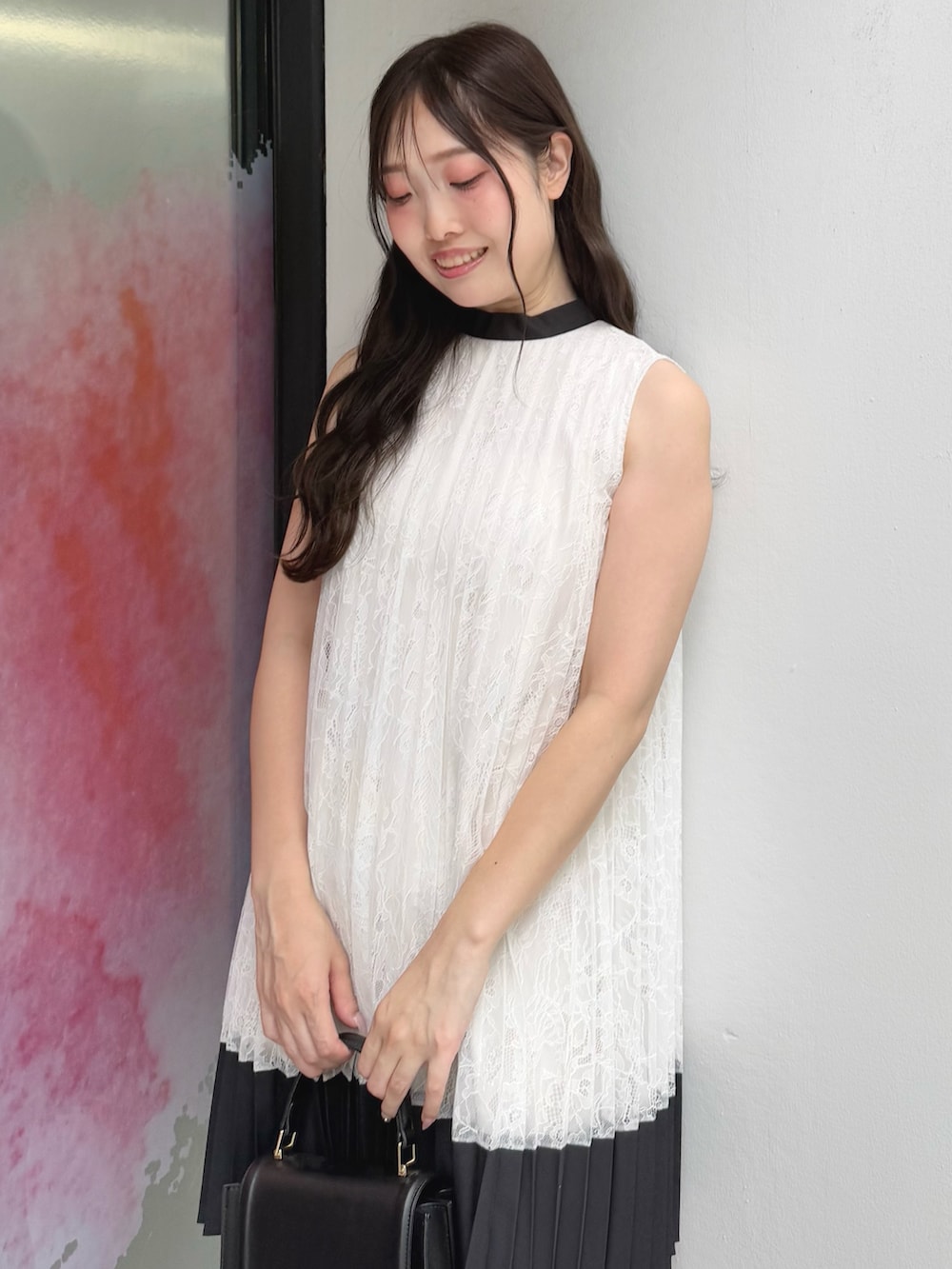 ホワイト系のワンピース、ブラック系のハンドバッグ、ブラック系のサンダルを着用したレディースの夏コーディネートの6枚目の写真