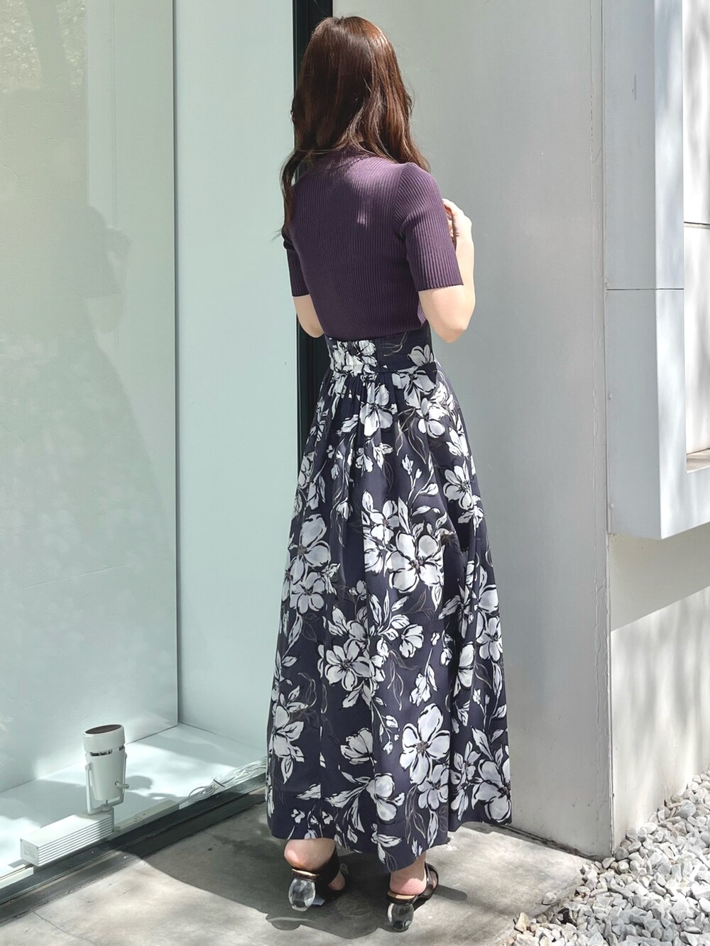 パープル系のスカート、ブラウン系のサンダル、パープル系のニット/セーターを着用したレディースの春コーディネートの3枚目の写真